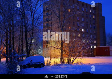 Eine ruhige Winternächteszene mit zartem Schnee und einem wunderschön beleuchteten Gebäude Stockfoto