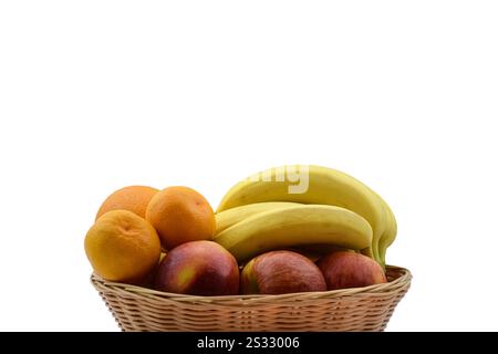 Ein Korb gefüllt mit verschiedenen Früchten vor einem scharf weißen Hintergrund. Stockfoto