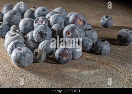 Blaubeeren auf einem alten Holztisch, frontal. Stockfoto