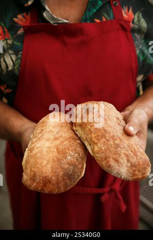 bäcker hält frisch gebackenes Brot aus der Nähe Stockfoto