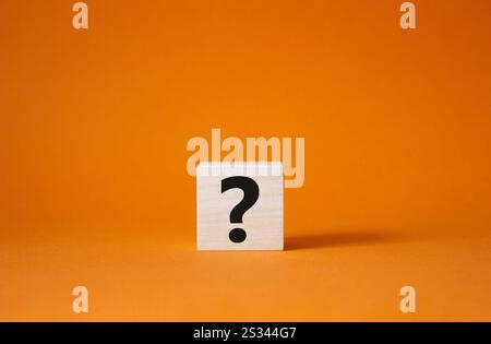 Fragezeichensymbol. Fragezeichen von Konzeptwörtern auf Holzwürfel. Wunderschöner orangefarbener Hintergrund. Geschäftlich und Fragezeichen. Kopierbereich. Stockfoto