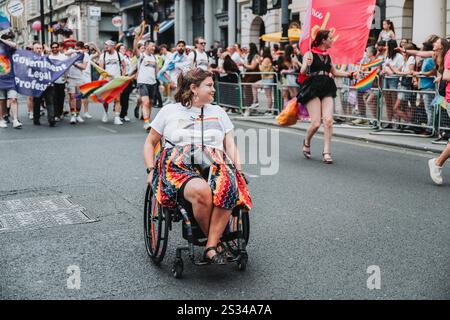 Person im Rollstuhl, die an der Pride of London 24 Parade teilnimmt Stockfoto