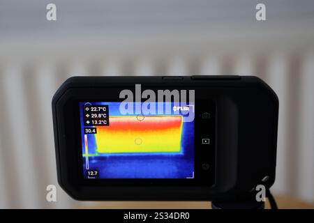 Wärmebildkamera zeigt einen Zentralheizungskörper FLIR zeigt Temperaturänderungen im Vergleich zu einem Heizungskonzept an und berechnet Energiekosten Stockfoto