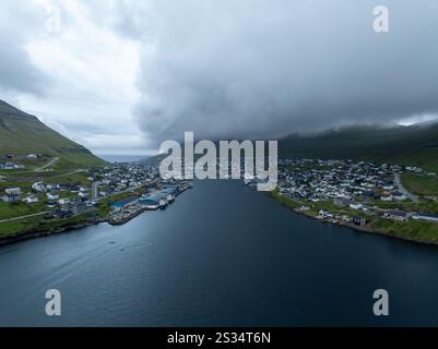 Wunderschöner Blick aus der Vogelperspektive auf die Stadt Klaksvik auf den Fareo-Inseln mit ihren bunten Häusern und dem atemberaubenden Kanal und Blick auf den majestätischen Kunoy Park Stockfoto