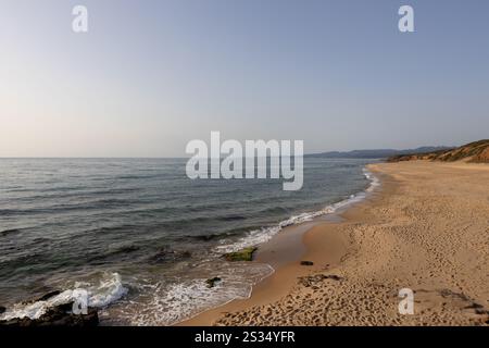Ruhiger Sandstrand mit sanften Wellen Stockfoto