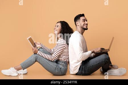 Online-Unterhaltung. Glückliches Nahost-Paar Mit Laptop Und Digitalem Tablet Stockfoto