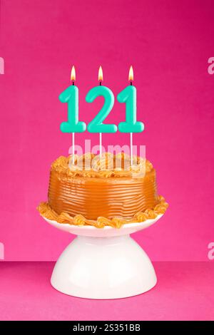 Geburtstagskarte mit Kerze Nummer 121 - Kuchen mit Dulce de leche Zuckerguss. Stockfoto