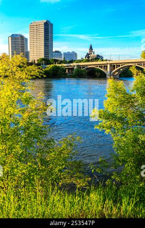 Eine Stadt mit einem Fluss und einer Brücke darüber. Die Brücke ist hoch und das Wasser ist ruhig Stockfoto