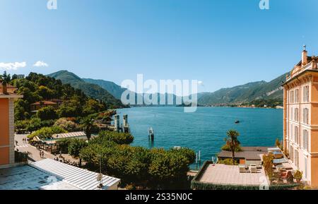 Atemberaubender Panoramablick auf den Comer See von Bellagio aus, mit farbenfrohen Gebäuden, üppigen grünen Bergen und tiefblauem Wasser unter klarem Himmel Stockfoto