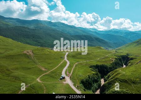 Majestätische Bergregion in Mestia, Georgia, mit sanften Hügeln, gewundenen Pfaden und traditionellem Turm unter hellem Himmel, die ein Gefühl von Entdeckung und Frieden wecken. Stockfoto