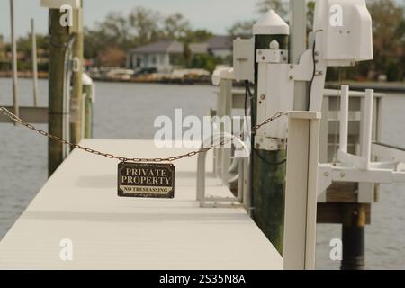 Niedriger Weitwinkelblick über eine Bootsanlegestelle mit einem Schild an der Kette, privates Grundstück kein Betreten. Coffee Pot Bay in St. Petersburg, FL. Leerer Bootssteg. S Stockfoto