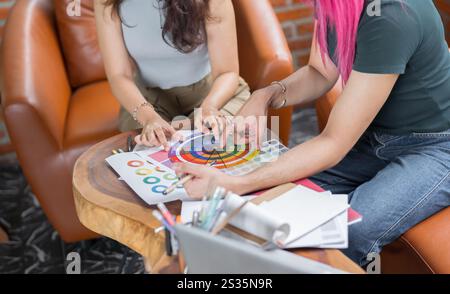 LGBTQ+ Transgender Mann schöner authentischer Spezialist mit rosafarbenen Haaren und nicht-binären Trans, die zusammen arbeiten Design im kreativen Arbeitsplatzteam W Stockfoto