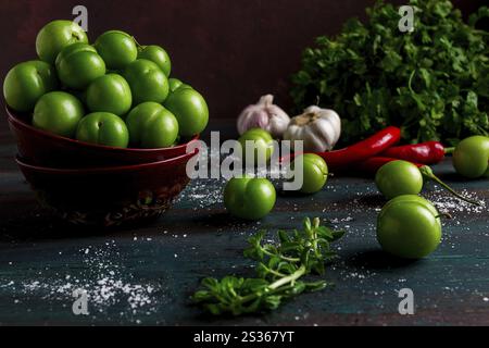 Tkemali, Pflaume der grünen Kirsche, mit Zutaten für Sauce, Koriander, Minze, Paprika, Knoblauch, Auf einem Holztisch, Nahaufnahme, rustikal, Essenshintergrund, kein p Stockfoto