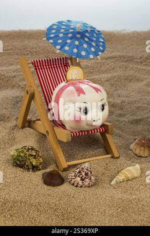 Liegestuhl mit Euro-Währung am Sandstrand. Symbolfoto für Reise-, Urlaubs- und Urlaubskosten. Sparen im Urlaub Österreich Stockfoto