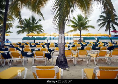 Ein Strand mit Reihen leerer Liegestühle, die auf dem Sand stehen. Stockfoto
