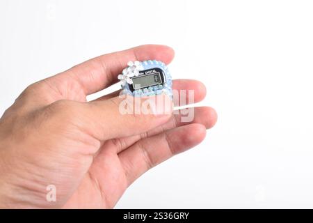 Hand hält digitale Gebetsperlen Handzähler isoliert auf weißem Hintergrund. Wird von Muslimen in Gottesdiensten verwendet, besonders im heiligen Monat Ramadan Stockfoto