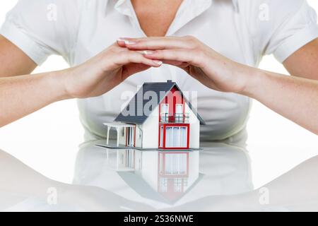 Eine Frau beschützt Ihr Haus und Ihr Zuhause. Gute Versicherungen und seriöse Finanzierungen sorgen für ein beruhigendes Gefühl. Österreich Stockfoto