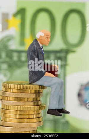 Rentner sitzt auf einem Haufen Geld, symbolisches Foto für Rente, Altersvorsorge, Alterssicherung Österreich Stockfoto