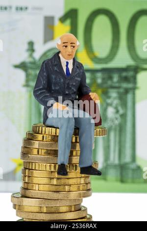 Rentner sitzt auf einem Haufen Geld, symbolisches Foto für Rente, Altersvorsorge, Alterssicherung Österreich Stockfoto