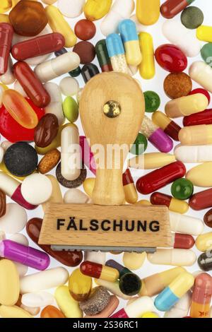 Stempel auf bunten Tabletten, symbolisches Foto für Arzneimittelfälschung und Produktpiraterie Österreich Stockfoto