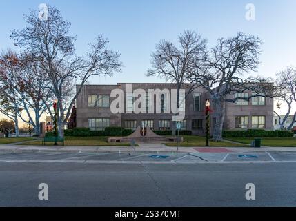 Lichter auf Bäumen sorgen für Weihnachtsszene rund um das historische Burnet County Court House in Texas Stockfoto
