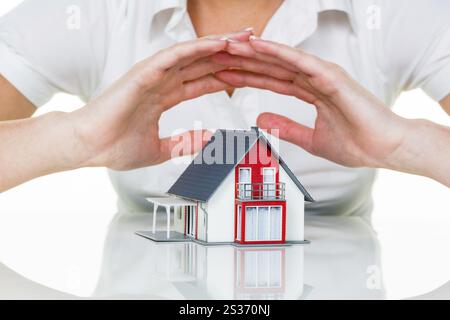 Eine Frau beschützt Ihr Haus und Ihr Zuhause. Gute Versicherungen und seriöse Finanzierungen sorgen für ein beruhigendes Gefühl. Österreich Stockfoto