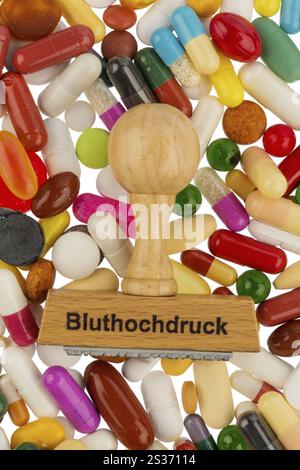 Stempel auf bunten Tabletten, symbolisches Foto für hohen Blutdruck, Verschreibung und Medikamente Stockfoto