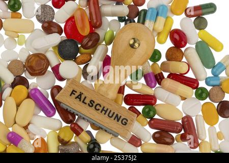 Stempel auf bunten Tabletten, symbolisches Foto für Arzneimittelfälschung und Produktpiraterie Österreich Stockfoto