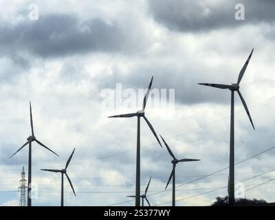 Windturbinen und Strommasten in einem Windpark. Windkraftwerk für erneuerbare Energien. Österreich Stockfoto