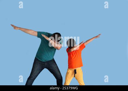 Geschiedener Alleinvater mit seinem 9-jährigen dunkelhäutigen Latino-Sohn tanzen als Zeichen von Sieg und Triumph beim Spielen und Spaß Stockfoto