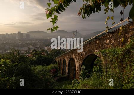 Eine Bogensteinmauer, die die Standseilbahn zum berühmten Penang Hill bei Sonnenaufgang stützt Stockfoto