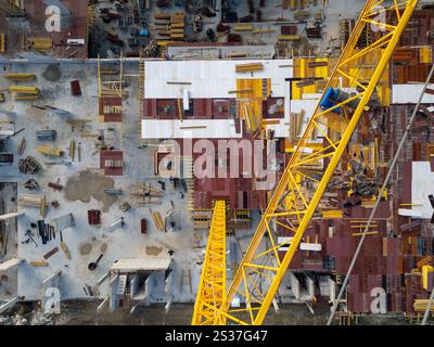 Auf der Baustelle werden in einem städtischen Gebiet unter hellem Sonnenlicht leuchtende Materialien und Geräte präsentiert Stockfoto