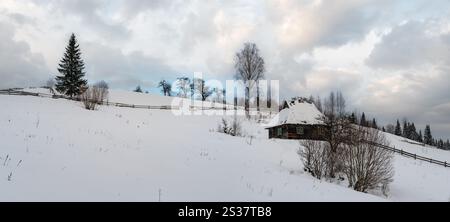 Landschaft Hügel, Haine und Ackerland im Winter abgelegenen alpinen Bergdorf, und kleine alte verlassene Haus am Hang Stockfoto