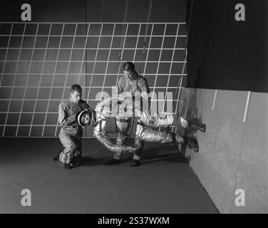 11. Dezember 1963 - Hampton, Virginia, USA - in diesem Bild vom 11. Dezember 1963 bereiten Techniker ein Testobjekt für Studien mit dem Reduced Gravity Walking Simulator im Langley Research Center der NASA in Hampton, Virginia vor. Diese Position bedeutete, dass die Beine einer Person nur ein Sechstel ihres Gewichts erlebten, was gleichbedeutend mit der Lage auf der Mondoberfläche war. Der Simulator wurde verwendet, um das Motiv beim Gehen, Springen oder Laufen zu untersuchen; er wurde auch verwendet, um Apollo-Astronauten für Aufgaben in der unbekannten Mondumgebung zu trainieren. (Kreditbild: © NASA/ZUMA Press Wire) REDAKTIONELLE VERWENDUNG AUF Stockfoto