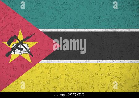 Mosambikanische Flagge in hellen Farben auf alten Reliefputzwänden aus nächster Nähe dargestellt. Strukturiertes Banner auf rauem Hintergrund. Mosambikanische Flagge abgebildet Stockfoto