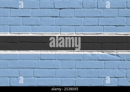 Botswana-Flagge in Malfarben auf alten Ziegelwänden aus nächster Nähe dargestellt. Strukturiertes Banner auf großem Mauerwerk Hintergrund. Botswana Flagge abgebildet in Stockfoto