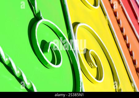 Metallstruktur eines Stücks farbiger Wand mit geschmiedetem Muster. Regenbogenfarben. Metallstruktur eines Stücks farbiger Wand mit geschmiedetem Muster Stockfoto