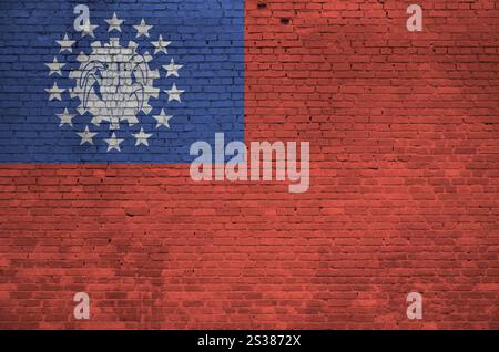 Myanmar-Flagge in Malfarben auf alten Ziegelwänden aus nächster Nähe dargestellt. Strukturiertes Banner auf großem Mauerwerk Hintergrund. Myanmar-Flagge abgebildet in Stockfoto