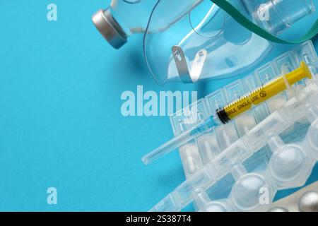 Coronavirus-Behandlungskonzept. Ein medizinischer Gesichtsmasken-Vernebler für die Behandlung der Atemwege und Ampullen flach auf blauem Hintergrund gelegt. Stockfoto