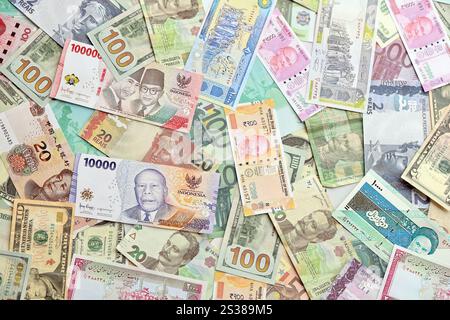 Viele Banknoten unterschiedlicher Währung. Hintergrund großer Mengen zufälliger Geldrechnungen aus nächster Nähe. Viele Banknoten unterschiedlicher Währung. Hintergrund von Stockfoto