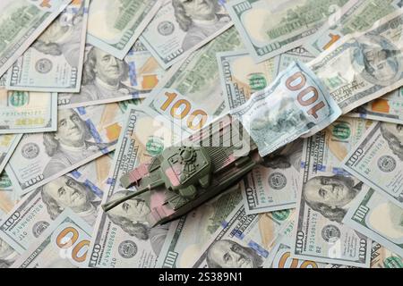 Tank auf zerknitterten 100-Dollar-Banknoten. Hintergrund der Kriegsfinanzierung und des militärischen Unterstützungspreises für die Vereinigten Staaten von Amerika Stockfoto