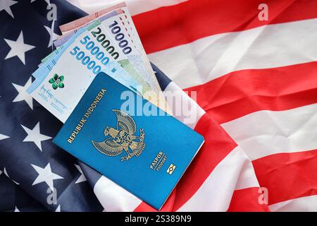 Blauer Indonesien Pass und Geld auf der US-Nationalflagge Hintergrund Nahaufnahme. Tourismus und Diplomatie. Blaue Republik Indonesien Stockfoto