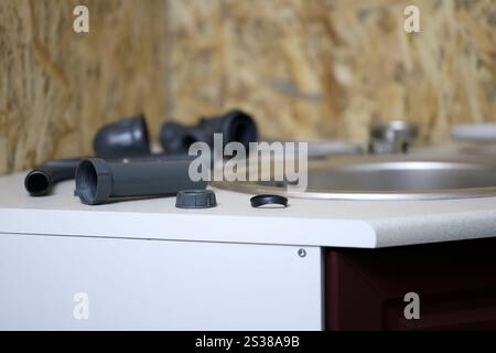 Klempner Werkzeuge und Wasserhahn bereit für die Installation in der Nähe des Waschbeckens auf der Arbeitsplatte in der Küche. Anschlüsse für die Installation des Wasserhahns für den Stockfoto