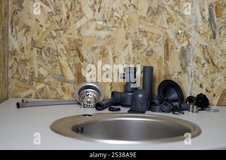 Klempner Werkzeuge und Wasserhahn bereit für die Installation in der Nähe des Waschbeckens auf der Arbeitsplatte in der Küche. Anschlüsse für die Installation des Wasserhahns für den Stockfoto
