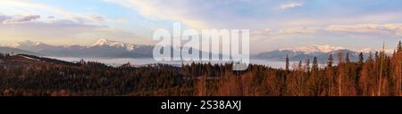 Frühjahrsdämmerung Karpaten-Berglandschaft mit schneebedeckten Bergrücken in Far, Ukraine. Von links nach rechts - Hoverla, Petros, Blyznycja. Stockfoto