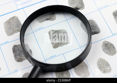 Fingerabdrücke Karte Polizeiformular auf A4-Tablet liegt auf dem Bürotisch mit Stift und Lupe nah oben Stockfoto