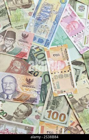 Viele Banknoten unterschiedlicher Währung. Hintergrund großer Mengen zufälliger Geldrechnungen aus nächster Nähe. Viele Banknoten unterschiedlicher Währung. Hintergrund von Stockfoto