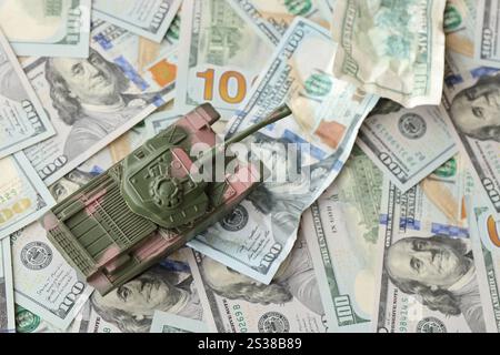 Tank auf zerknitterten 100-Dollar-Banknoten. Hintergrund der Kriegsfinanzierung und des militärischen Unterstützungspreises für die Vereinigten Staaten von Amerika Stockfoto