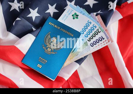 Blauer Indonesien Pass und Geld auf der US-Nationalflagge Hintergrund Nahaufnahme. Tourismus und Diplomatie. Blaue Republik Indonesien Stockfoto