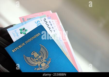 Blue Republic Indonesien Pass mit Geld und Flugtickets auf touristischen Rucksack Nahaufnahme. Tourismus und Reisekonzept. Blaue Republik Indonesien Stockfoto